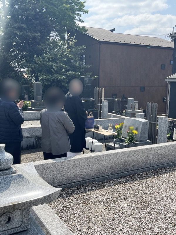神奈川県のお墓じまいの現場でお墓参りをする人々