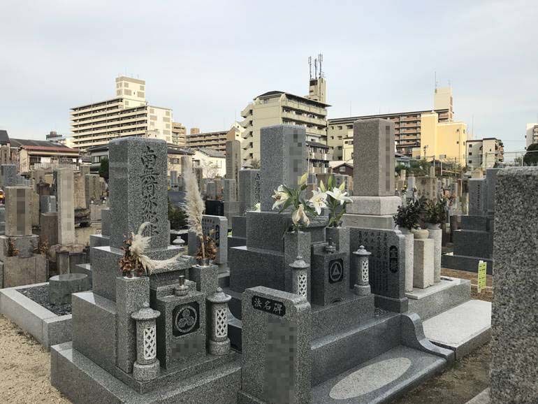 大阪市設 北霊園　思い思いの花を供えられた墓石