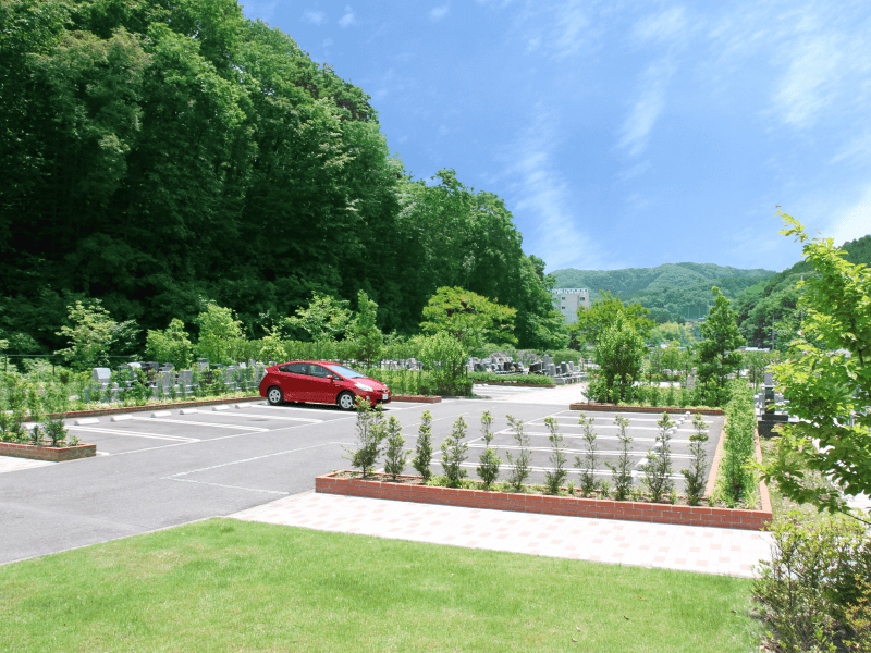 八王子上川霊園の駐車場に赤い車がとまっている様子